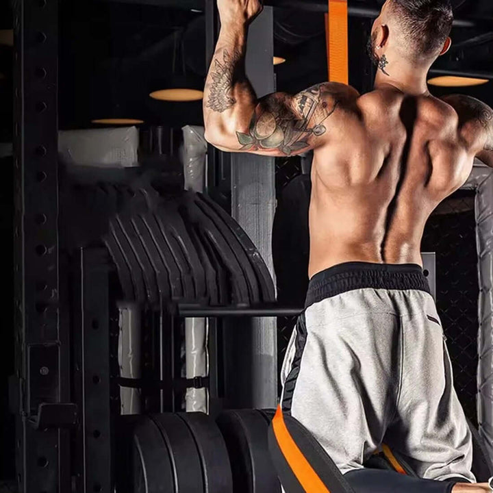 A man performing pull-ups using Strengthsphere Heavy Duty Pull Up Bands Set in a gym setting.
